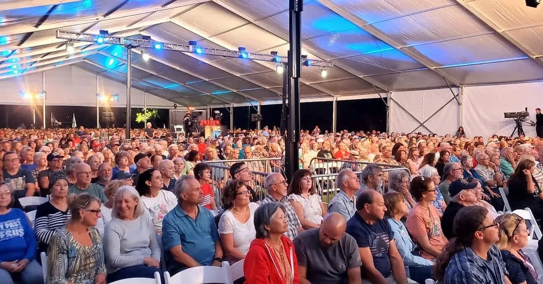 Christian believers worship beneath a large tent at FlashPoint's River at the Ranch revival in Wise County, Texas, October 2026.